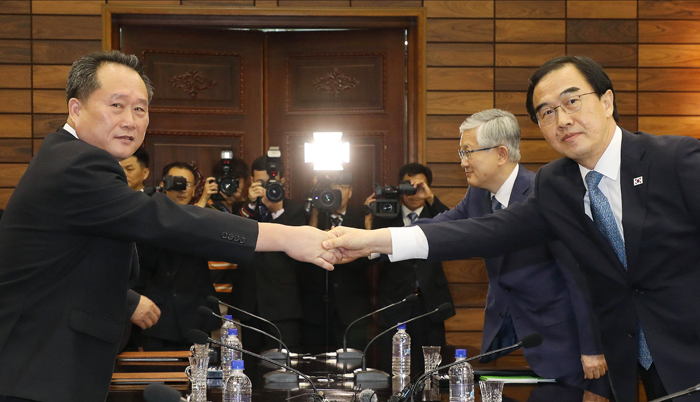 Le ministre de l'Unification, Cho Myoung-gyon (à droite) et son homologue nord-coréen se serrent la main après avoir tenu la quatrième réunion de haut niveau, le 13 août, au pavillon Tongilgak, dans le nord de Panmunjeom.