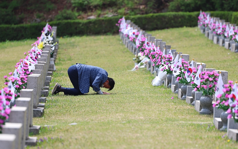 Un homme se recueille sur la tombe de son frère aîné tué lors du soulèvement populaire du 19 avril 1960, au cimetière national du 19-Avril, à Séoul, le 19 avril 2024.