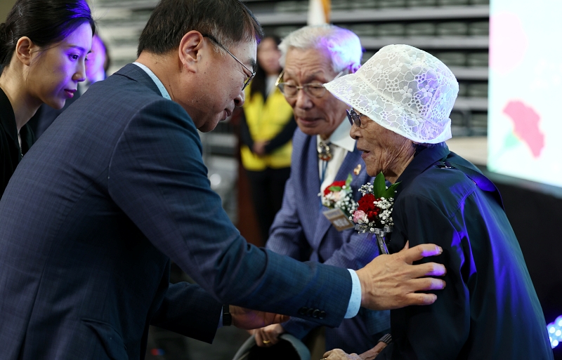 Le premier adjoint au maire de Séoul Kim Sang-han remet des œillets à deux personnes âgées, Park Tae-nam (96 ans) et Kim Ok-rye (93 ans), lors de la cérémonie de la 52e fête des parents, qui s’est tenue au gymnase Jangchung de Séoul, le 8 mai 2024.