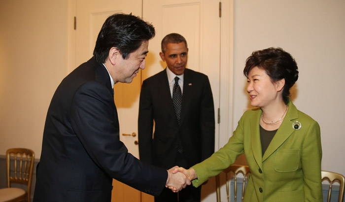 박근혜 대통령(오른쪽)이 25일 네덜란드 헤이그에서 열린 한•미•일 정상회담에서 아베 신조 일본 총리(왼쪽)와 악수를 하고 있다. 가운데는 버락 오바마 미국 대통령. (사진: 연합뉴스)
