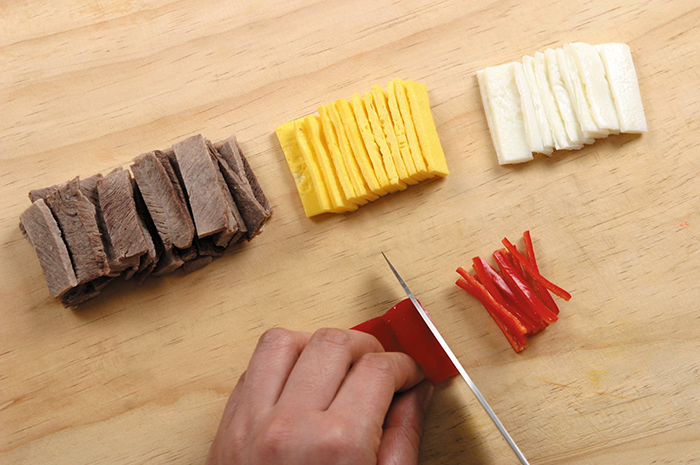 Slice the egg yolks, egg whites and red peppers into the similar-sized strips that are about 3 centimeters long and 0.3 centimeters wide. Make sure to slice the beef after it cools down as otherwise it may become brittle.