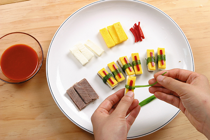 Layer the beef slices, the egg whites, egg yolks and red pepper strips into small stacks. Bind them in the middle with two turns of a watercress strip. Serve with the vinegar red pepper paste.