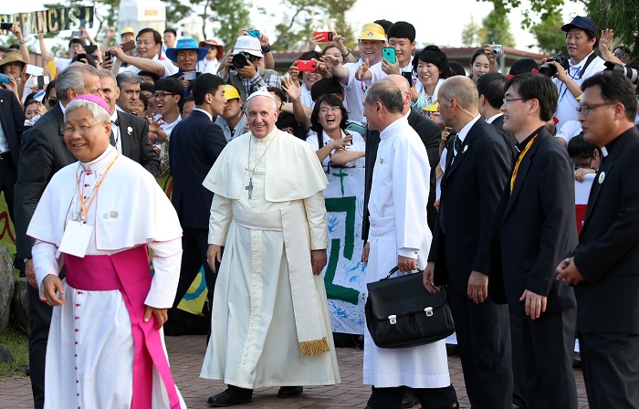 프란치스코 교황이 신도들과 인사를 나눈 뒤, 환하게 웃고 있다. 