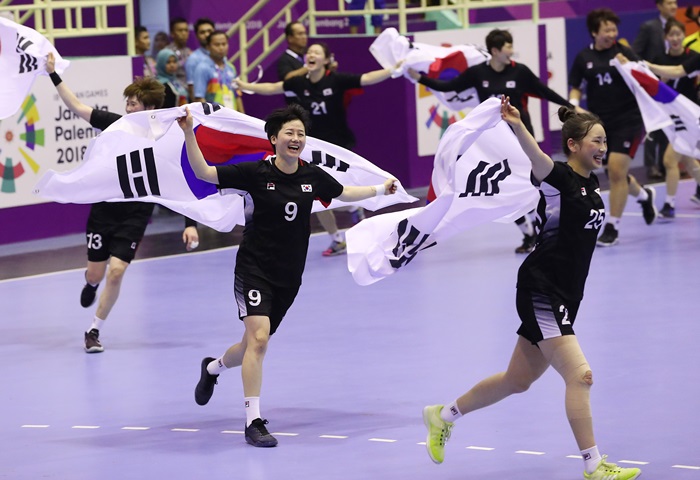 30일(현지시간) 한국 여자 핸드볼 대표팀이 인도네시아 자카르타 포키 찌부부르 스타디움에서 열린 2018 자카르타-팔렘방 아시안게임 여자 핸드볼 결승에서 중국을 꺾고 금메달을 목에 걸었다. 한국 김온아(9번) 등 선수들이 태극기를 들며 경기장을 누비고 있다. 연합뉴스.