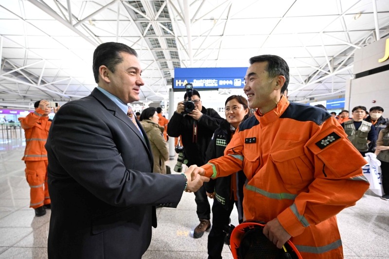 L'ambassadeur de Turquie en Corée du Sud, Salih Murat Tamer, échange une poignée de main avec un membre de l'équipe de secours KDRT à l'aéroport international d'Incheon, le 7 février 2023. 
