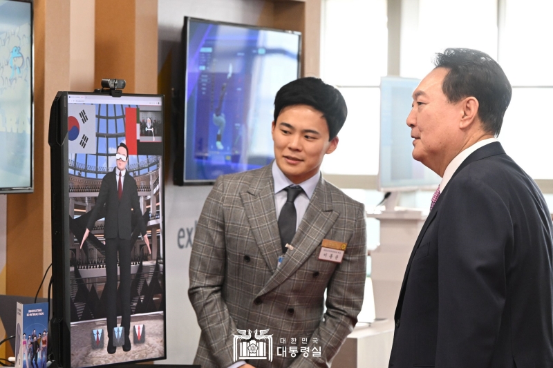 Le président Yoon Suk Yeol écoute un exposé de Lee Dong-yun, PDG de la startup EntreReality, sur l'équipement de pointe « avatar à suivi de mouvement », avant une réunion intitulée « Conversation avec les hommes d'affaires des petites et moyennes entreprises sur les réalisations de la visite d'État aux Émirats arabes unis (EAU) » et organisée au bureau présidentiel à Séoul, le 24 février 2023. ⓒ Bureau du Président 