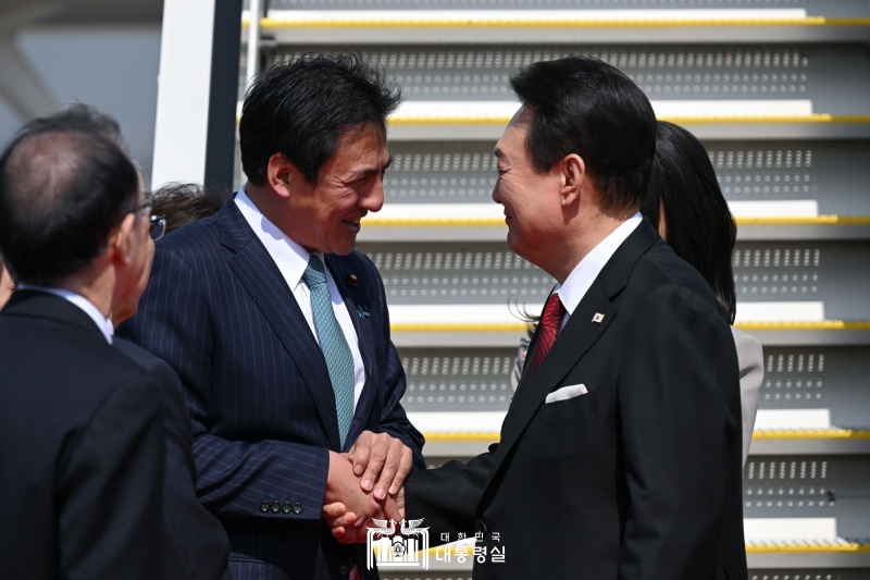 Le président Yoon Suk Yeol échange une poignée de main avec le ministre japonais d'État aux affaires étrangères TAKEI Shunsuke à l'aéroport international de Haneda à Tokyo, le 16 mars 2023. Ce voyage du président sud-coréen marque la reprise de la « diplomatie de la navette » une visite bilatérale régulière des dirigeants des deux pays, suspendue pendant 12 ans. 