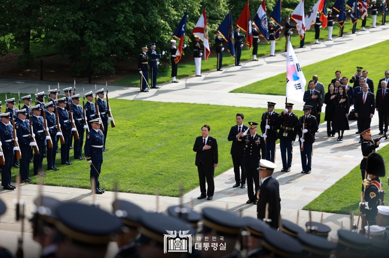 Le président Yoon Suk Yeol et son épouse Kim Keon Hee saluent le drapeau national lors de leur visite au cimetière militaire d'Arlington, aux États-Unis, le 25 avril 2023.
