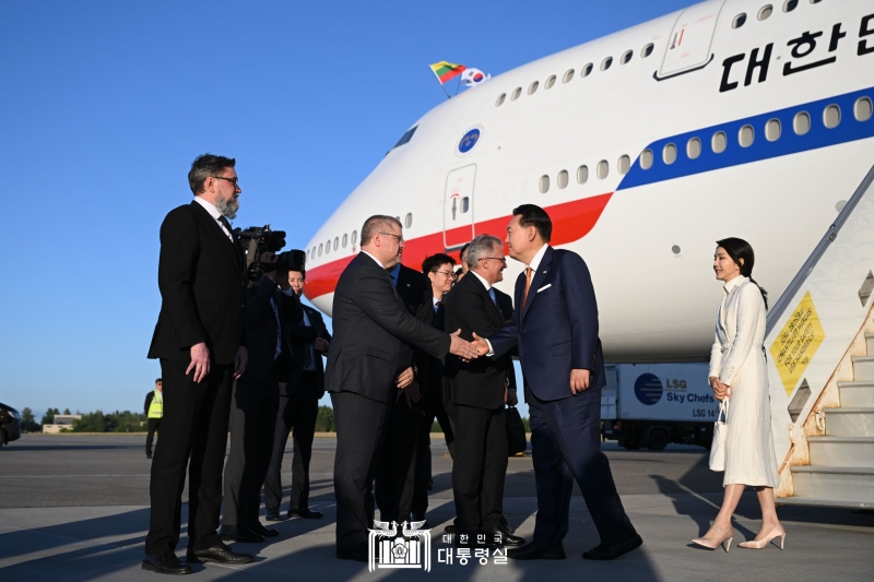 Yoon Suk Yeol et Kim Keon Hee saluent les membres de la délégation lituanienne venue les accueillir à leur arrivée à l’aéroport de Vilnius, en Lituanie, le 10 juillet 2023.
