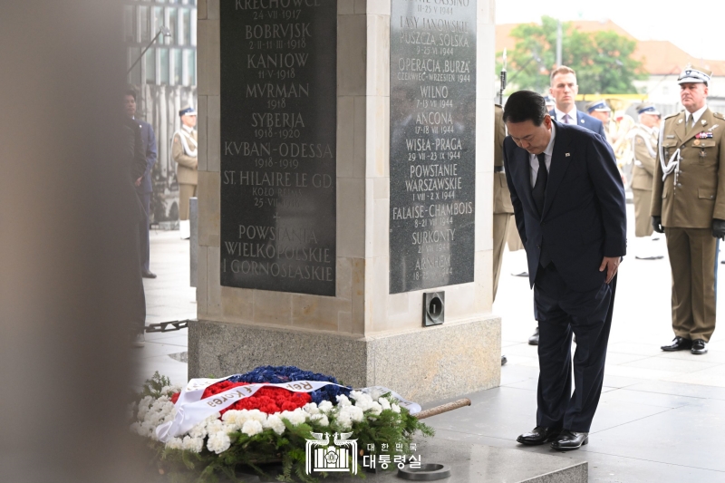 Yoon Suk Yeol se receuille devant la tombe du soldat inconnu, à Varsovie, le 13 juillet 2023. Les dirigeants étrangers ont pour coutume de visiter ce lieu de receuillement dédié aux soldats ayant combattu pour la Pologne au cours de l’histoire.
