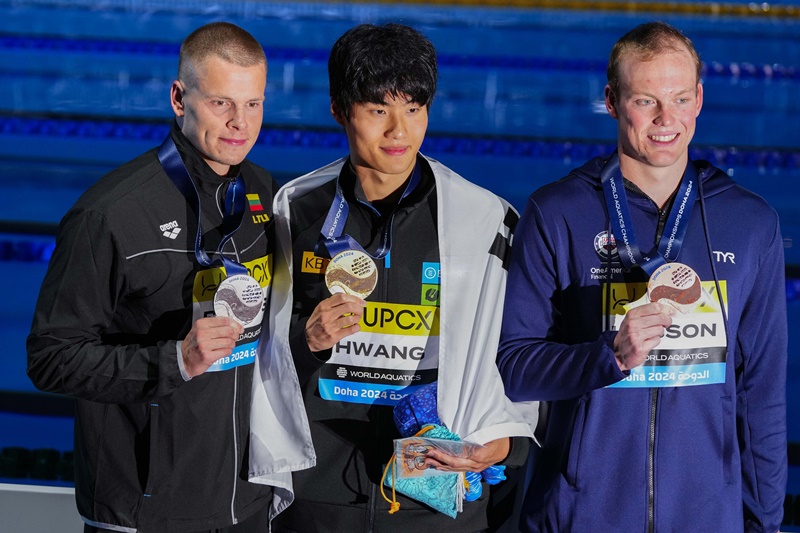 Hwang Seon-woo pose avec sa médaille d’or entouré du Lituanien Danas Rapšys (à gauche) et de l’Américain Luke Hobson, après sa victoire à l’épreuve du 200 m nage libre lors des championnats du monde de natation de Doha, au Qatar, le 13 février 2024. © Agence de presse Yonhap
