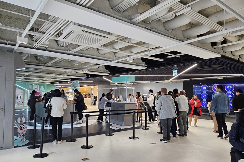 Des touristes étrangers font la queue pour goûter des biscuits coréens, au cinquième étage de l’HiKR Ground, à Séoul, le 3 avril 2024. © Cao Thi Ha / Korea.net
