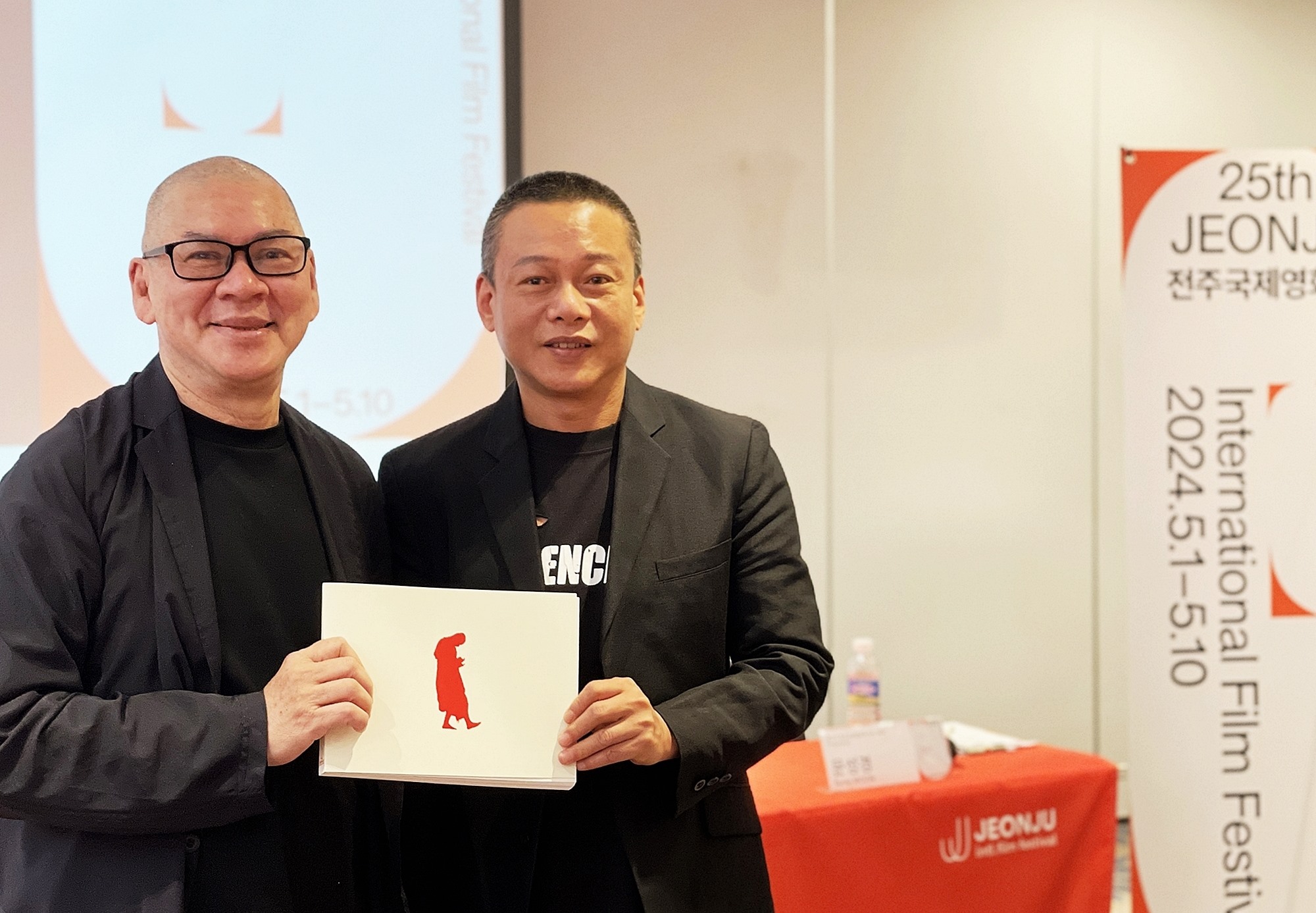 Tsai Ming-liang et Lee Kang-Sheng posent, tenant des brochures à la main, lors de la conférence de presse.