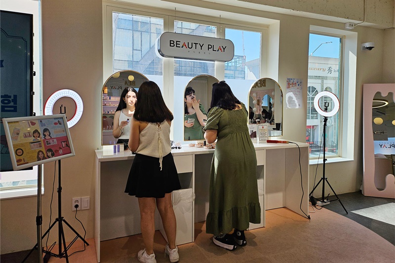 Dilek, une jeune Turque, peaufine son maquillage accompagnée d’une amie, au Beauty Play de Hongdae, le 9 mai 2024.
