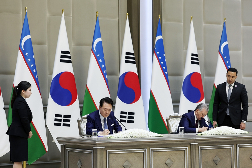 Le président Yoon Suk Yeol et son homologue ouzbek Shavkat Mirziyoyev signent une déclaration commune sur le renforcement de leur partenariat global stratégique au palais présidentiel Kuksaroy, à Tachkent, en Ouzbékistan, le 14 juin 2024. © Jeon Han / Korea.net