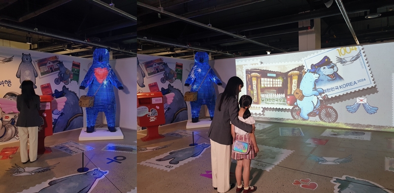 Un groupe de visiteurs découvre l’histoire derrière le timbre de l’ours bleu, lors de l’exposition annuelle du service des postes, sur l’île de Nodeul, à Séoul, le 18 juillet 2024. © Koh Hyunjeong / Korea.net