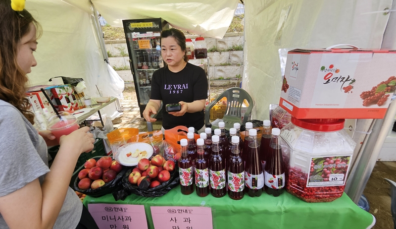 Une visiteuse achète un slush d’omija dans un stand qui vend des produits d’omija, comme la marmelade, le liqueur traditionnel et l’ade à base d’omija. © Lee Kyoung Mi / Korea.net