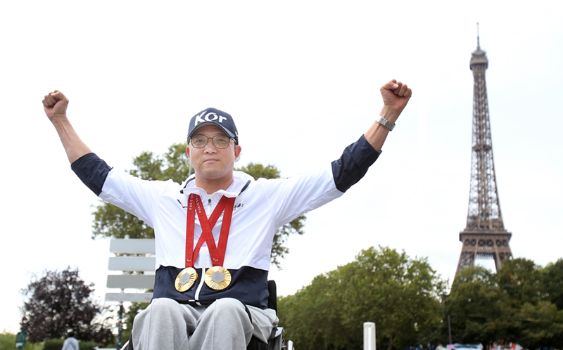 Park Jin-ho, qui a décroché deux médailles d’or en tir lors des Jeux paralympiques de Paris 2024, pose devant la tour Eiffel, à Paris, le 8 septembre 2024. © Comité paralympique coréen