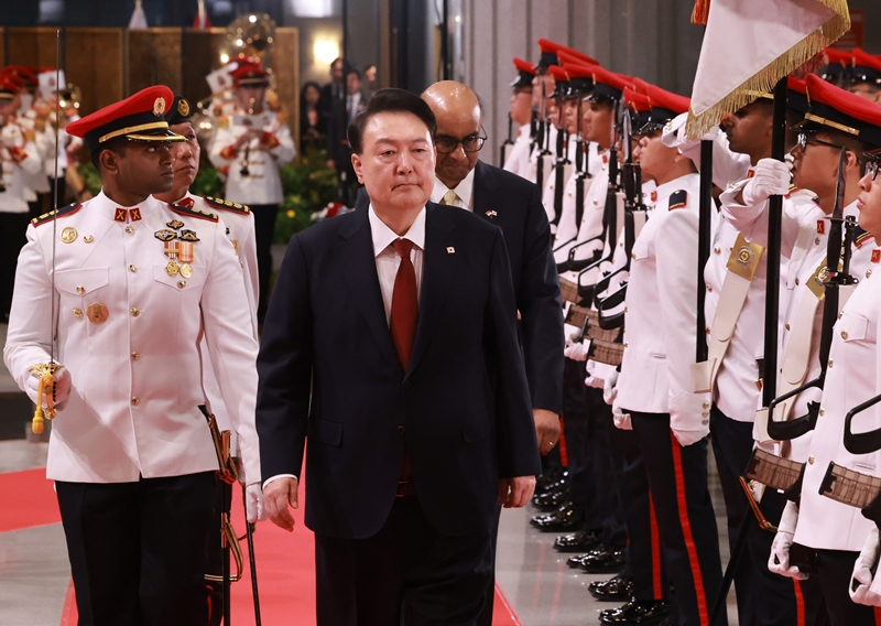 Le président Yoon Suk Yeol défile avec son homologue Tharman Shanmugaratnam au Parlement de Singapour, le 8 octobre 2024. © Agence de presse Yonhap 