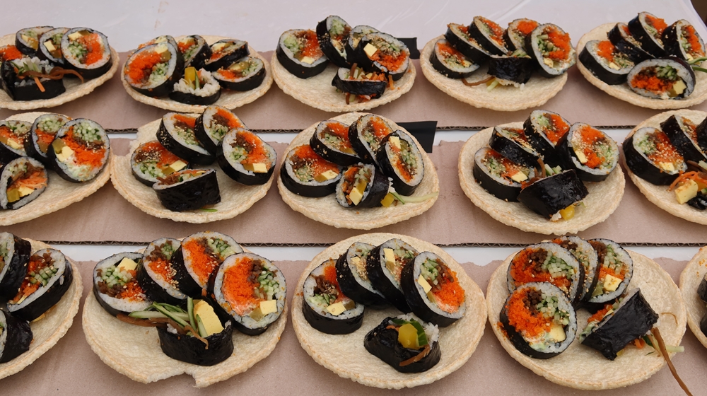 Certains stands du festival du gimbap de Gimcheon proposaient, à la place d’un récipient en plastique, de déposer les rouleaux de gimbap dans une galette de riz. Astucieux, pratique, et parfait pour un petit dessert. © Charles Audouin / Korea.net