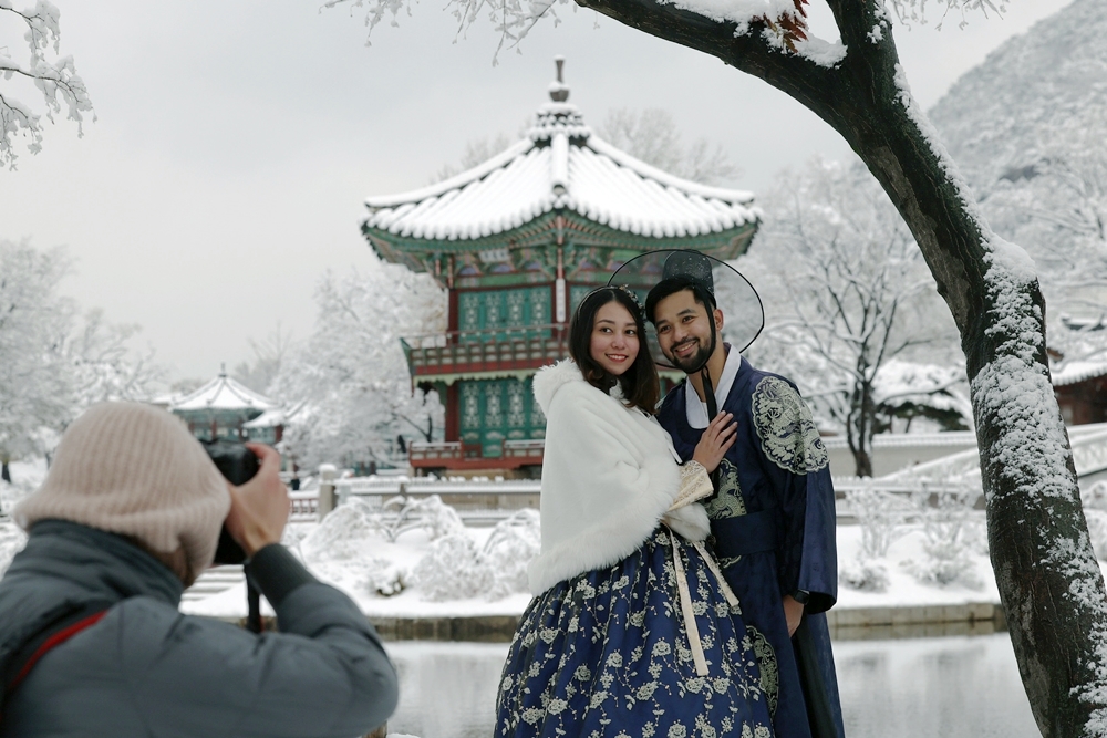 Un couple de touristes étrangers pose dans un palais Gyeongbokgung enneigé, le 27 novembre 2024. © Lee Jun Young / Korea.net