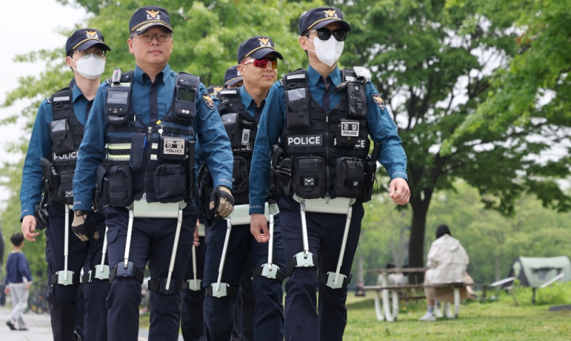 Un groupe de policiers équipés de technologies d’assistance à la marche effectue une patrouille, au Yeouido Hangang Park, à Séoul, le 11 mai 2025. © Agence de presse Yonhap