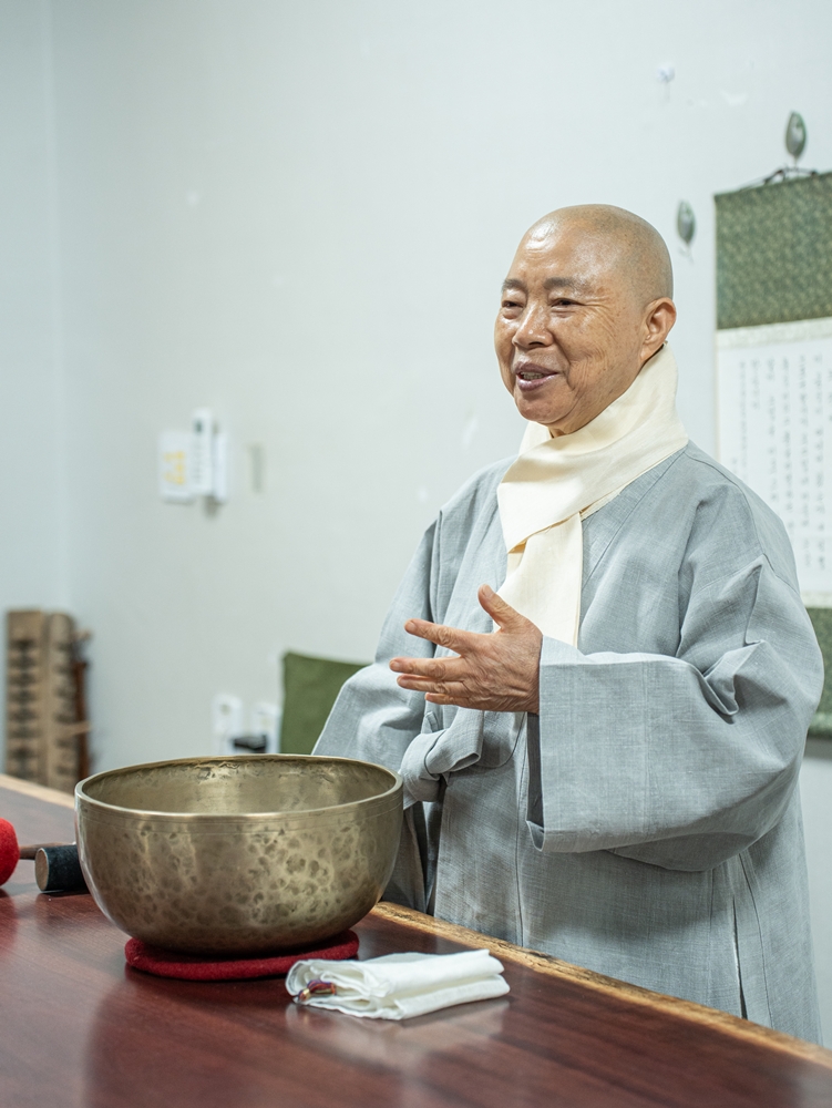 Jeongkwan, revêtue de sa tenue traditionnelle, s’apprête à réciter l’ogwange (les cinq strophes de la perspicacité), un chant psalmodié avant le repas. © Ministère de la Culture, des Sports et du Tourisme