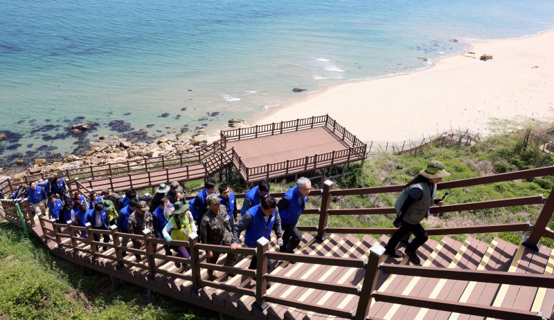 Le ministre de la Culture, des Sports et du Tourisme Yu In Chon monte les escaliers d’une structure installée sur le Goseong Peace Trail, le 8 mai 2025. © Ministère de la Culture, des Sports et du Tourisme