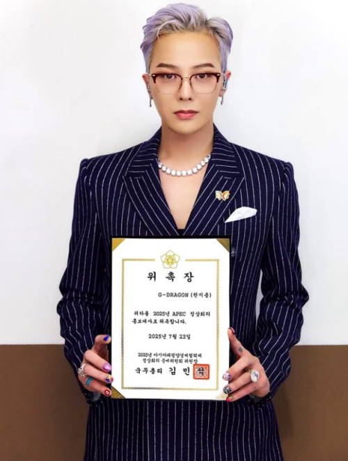 Le chanteur G-Dragon avec son certificat de nomination au poste d’ambassadeur du sommet de l’APEC. Photo publiée le 23 juillet sur son compte Instagram. © Compte Instagram de G-Dragon