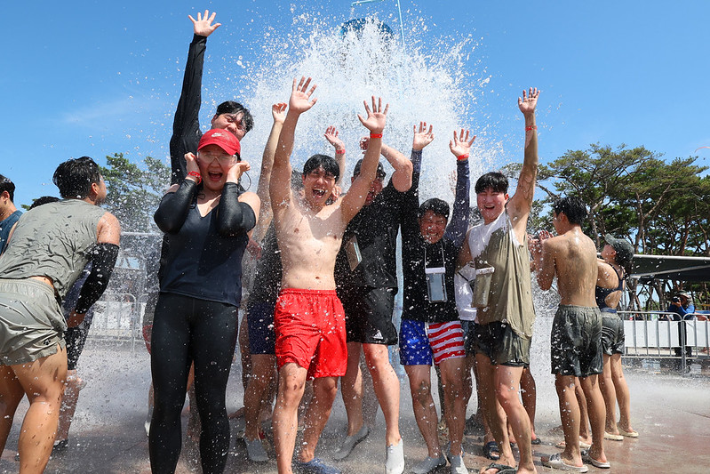 Un groupe de festivaliers s’amuse dans un jet d’eau du Boryeong Mud Festival, le 26 juillet 2025. © Lee Jeong Woo / Korea.net