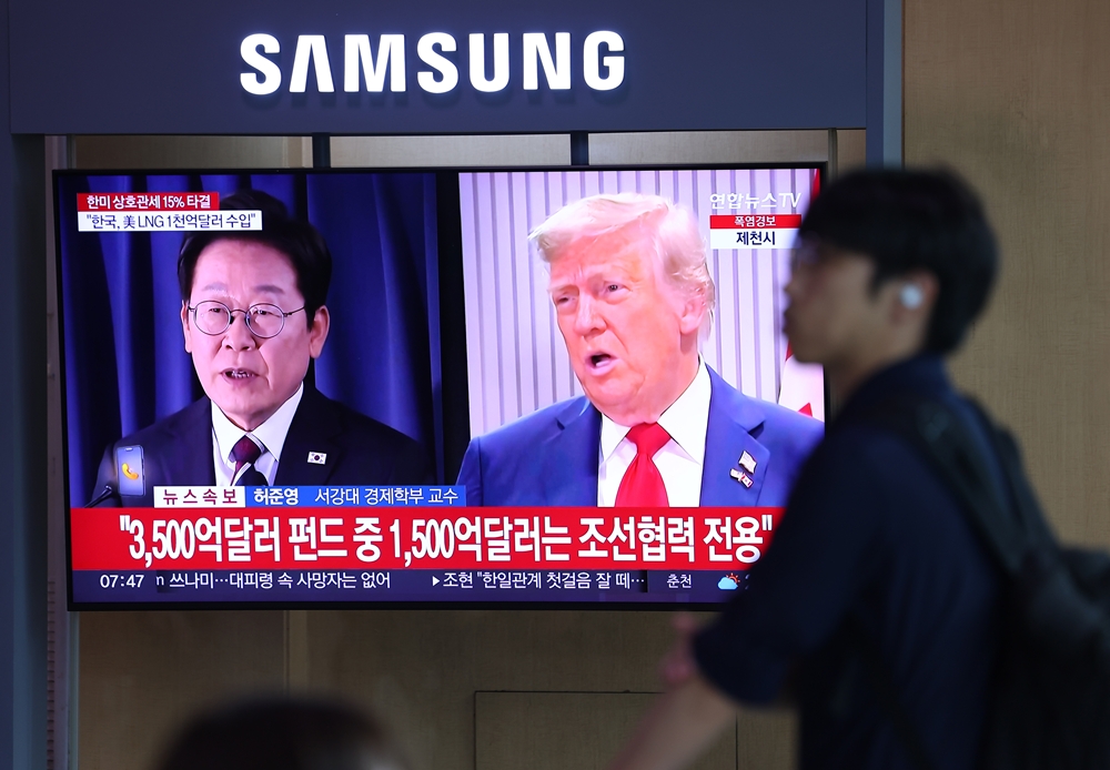 Une personne passe devant une télévision de la gare de Séoul, le 31 juillet 2025. © Agence de presse Yonhap