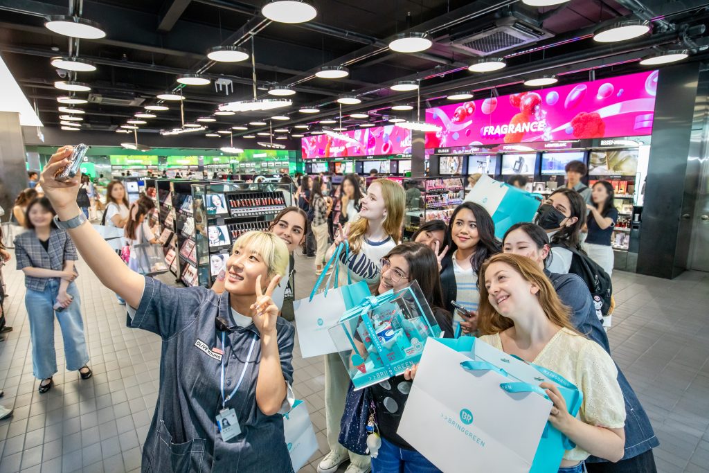 Un groupe de touristes étrangers posent après leur visite du Olive Young Myeongdong Global Store, à Séoul, en juin 2024. © Olive Young