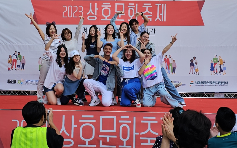 Les participants de l’atelier de danse K-pop posent sur scène lors du festival interculturel dans l’arrondissement de Gwanak, à Séoul, en 2023. © Seoul Foreign Resident Center 