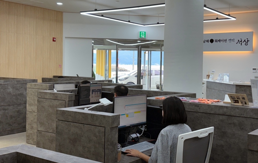 Des employés travaillent sur les ordinateurs du Seosang Workation Center, à Namhae, dans le Gyeongsang du Sud, le 19 septembre 2025. Le lieu, qui servait de gare maritime lors de l'Exposition internationale de Yeosu 2012, a été rénové en tant qu'espace de coworking en avril dernier. © Charles Audouin / Korea.net
