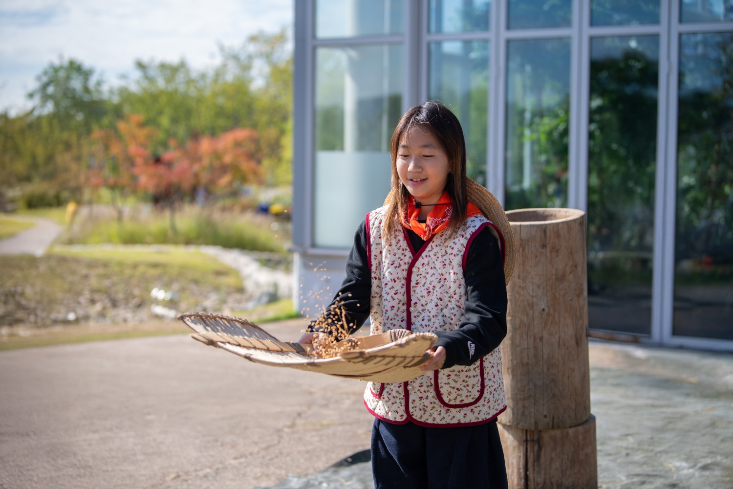 Une élève de l’école Guun de Suwon s’essaye au vannage des grains de riz au musée national de l’Agriculture de Suwon, le 22 octobre 2025. © Musée national de l’agriculture