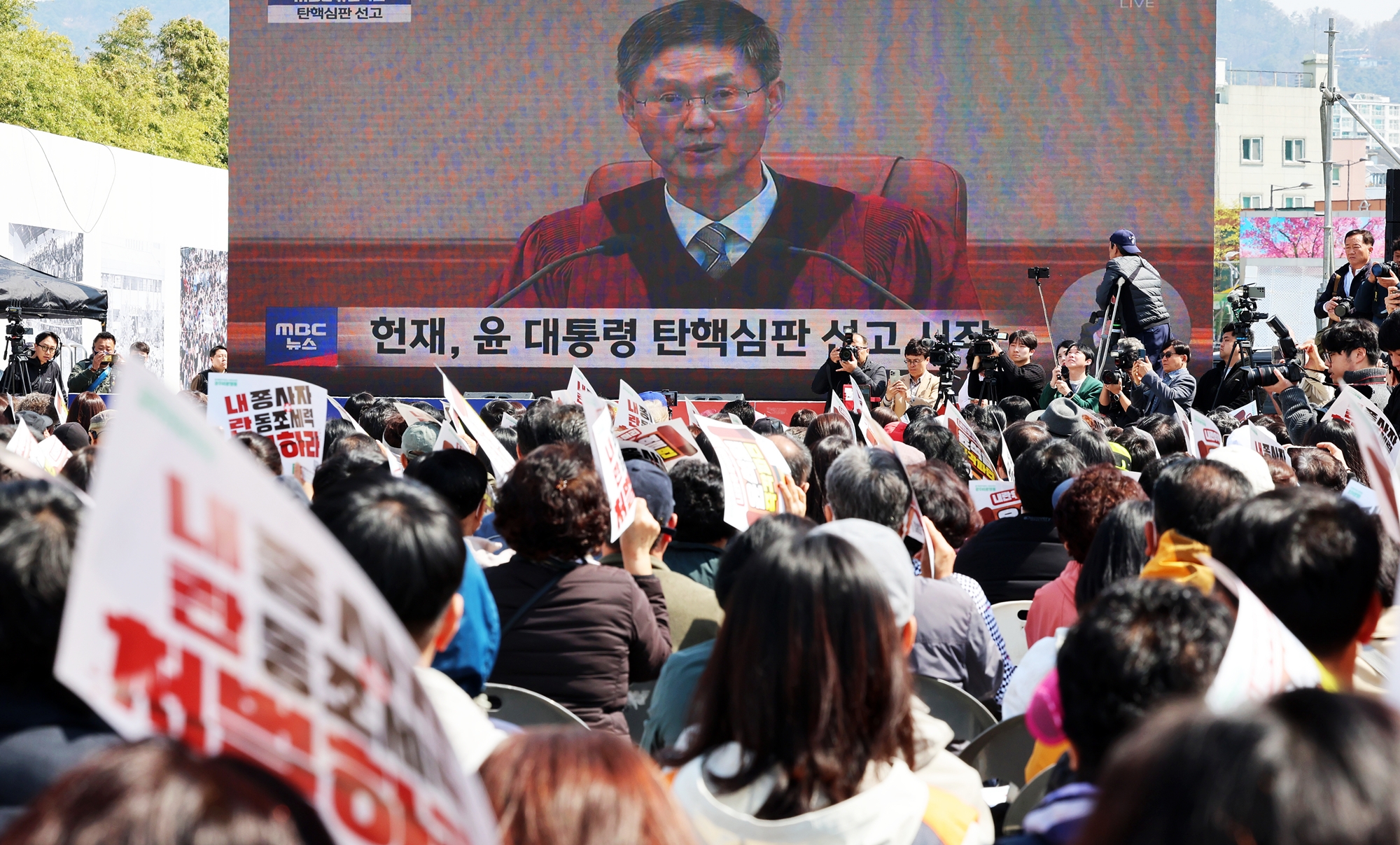 La foule assiste en direct au verdict de la Cour constitutionnelle sur la destitution de Yoon Suk Yeol de ses fonctions de président de la République de Corée, à Gwangju, le 4 avril 2025. Les huit juges de la Cour ont statué à l’unanimité en faveur de la procédure de destitution de l’ex-président déposée par l’Assemblée nationale le 14 décembre 2024, une dizaine de jours après que celui-ci ait proclamé l’état d’urgence en Corée, dans la soirée du 3 décembre. © Agence de presse Yonhap