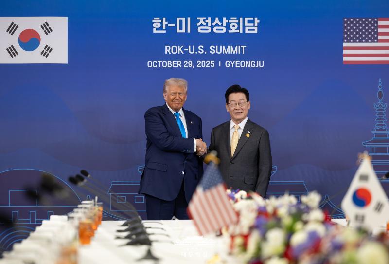 Le président Lee Jae Myung et son homologue américain Donald Trump se serrent la main à Gyeongju, le 29 octobre 2025, au terme de longues négociations tarifaires entre leurs deux pays. Séoul et Washington ont conclu un accord prévoyant une réduction ou une suppression de certains droits de douane, en contrepartie de 350 milliards de dollars d’investissements coréens aux États-Unis. Les tarifs sur les voitures et pièces détachées coréennes seront ramenés à 15 %, tandis que le traitement de la nation la plus favorisée sera appliqué à plusieurs produits, notamment les médicaments et les composants aéronautiques. © Bureau présidentiel de la République de Corée