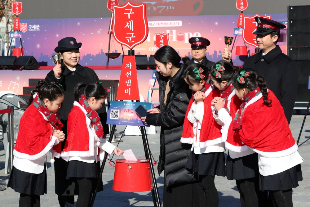 Les enfants font un don à l’Armée du Salut, dans les rues du quartier de Myeongdong, le 28 novembre 2025. © Lee Jeong Woo / Korea.net