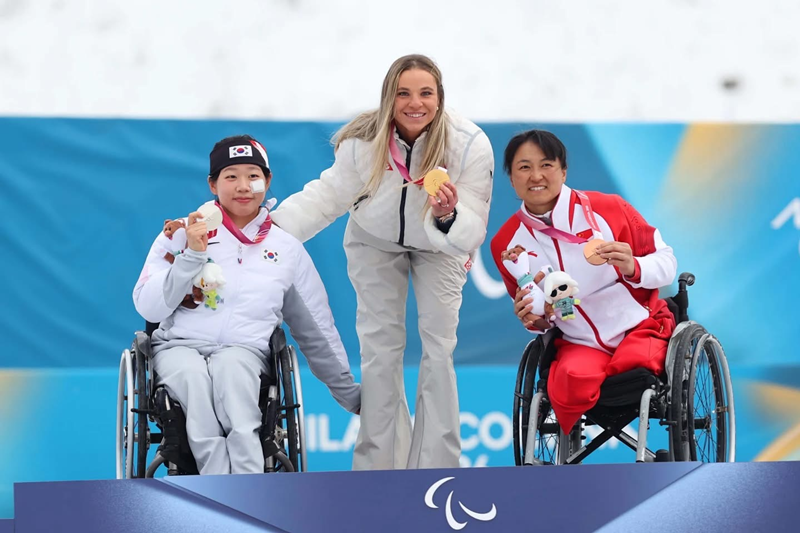 Kim Yunji (&agrave; gauche) sur le podium du 10 km de para ski de fond aux Jeux paralympiques d&rsquo;hiver de Milan-Cortina 2026, sur la piste de Tesero, le 11 mars 2026. &copy; Comit&eacute; paralympique cor&eacute;en