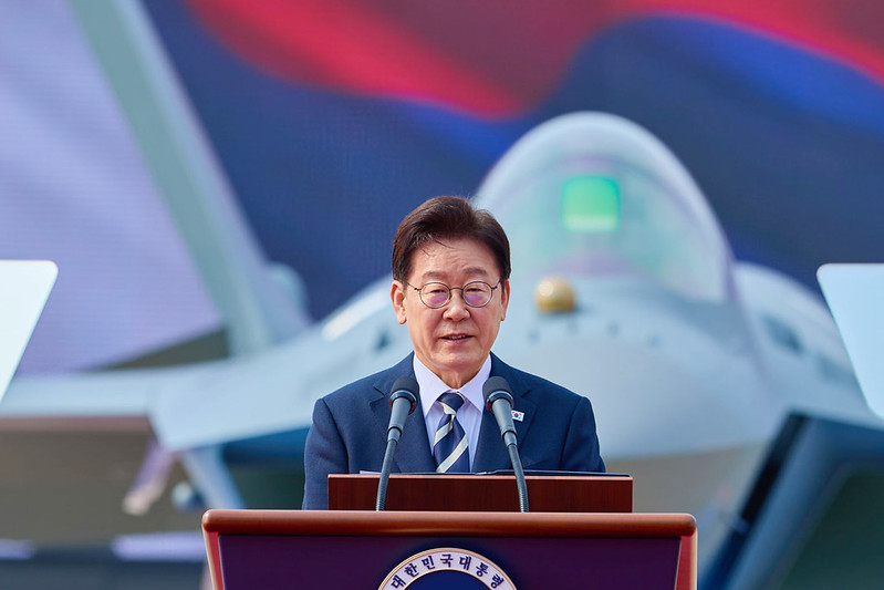 Le pr&eacute;sident Lee Jae Myung s&rsquo;exprime lors de la c&eacute;r&eacute;monie marquant la sortie du premier exemplaire du chasseur KF-21, pr&egrave;s du si&egrave;ge de la soci&eacute;t&eacute; Korea Aeroscpace Industries, &agrave; Sacheon, dans le Gyeongsang du Sud (Gyeongsangnam-do), le 25 mars 2026. &copy; Cheong Wa Dae