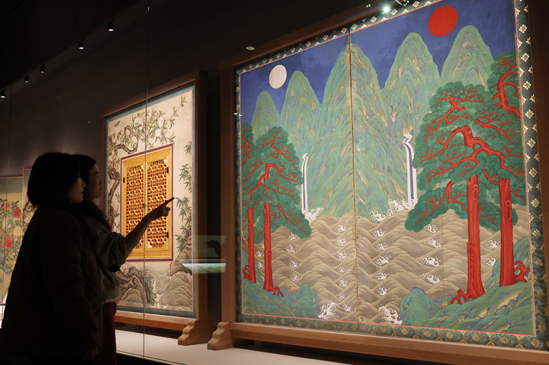 Deux visiteurs observent &laquo; Irworobongdo &raquo;, un paravent repr&eacute;sentant un soleil et une lune, expos&eacute; &agrave; l&rsquo;occasion de la r&eacute;ouverture de la galerie permanente de calligraphie et de peinture du Mus&eacute;e national de Cor&eacute;e, &agrave; S&eacute;oul, le 25 f&eacute;vrier 2026. &copy; Lee Jeong Woo / Korea.net