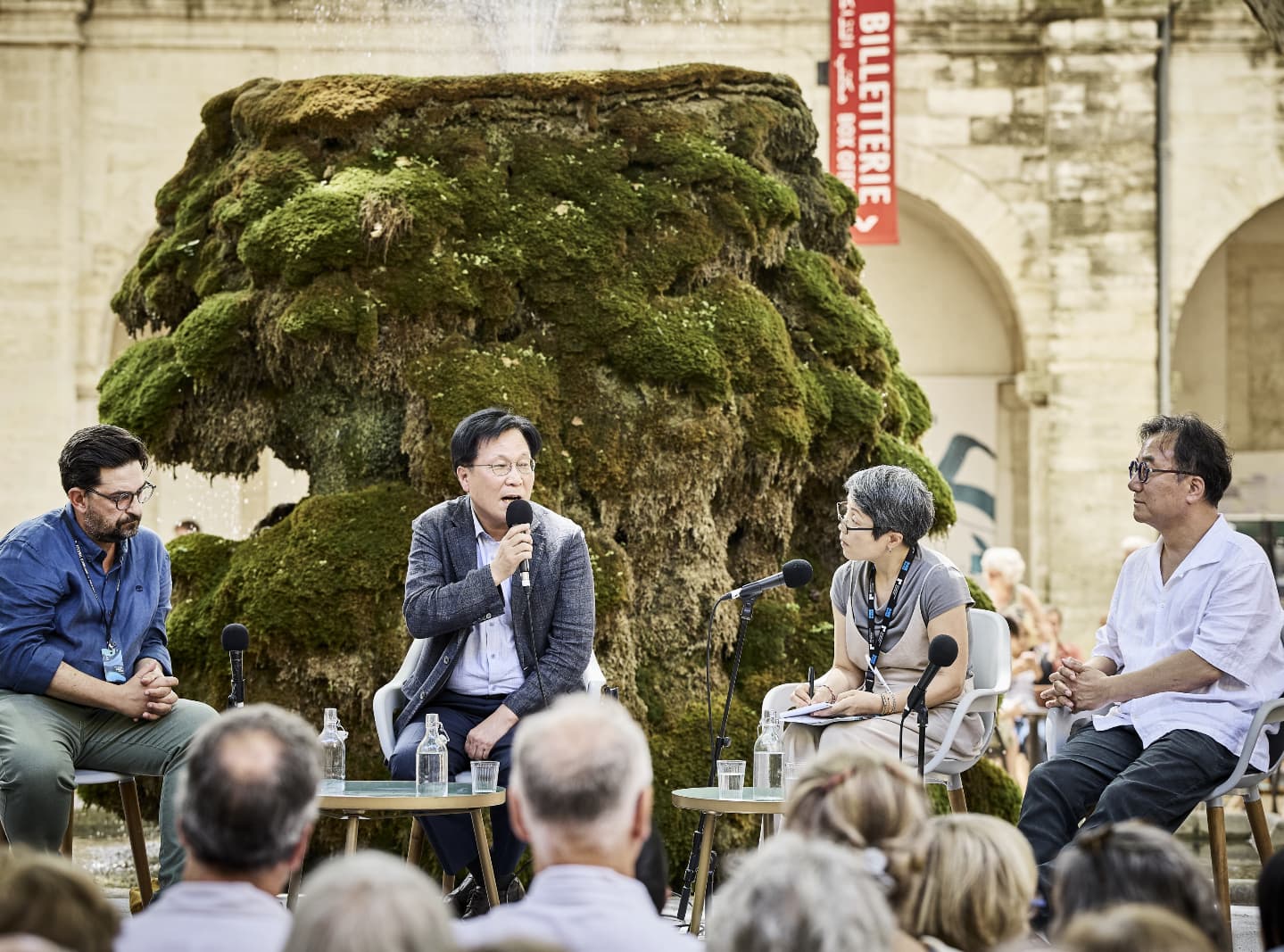 Le directeur du Korea Arts Management Service, Kim Jang-ho (au centre), s&rsquo;exprime aux c&ocirc;t&eacute;s du directeur artistique du festival d&rsquo;Avignon, Tiego Rodrigues (&agrave; gauche), et de Kyu Choi, directeur artistique du Seoul Performing Arts Festival (&agrave; droite), &agrave; Avignon, le 22 juillet 2025. &copy; Korea Arts Management Service