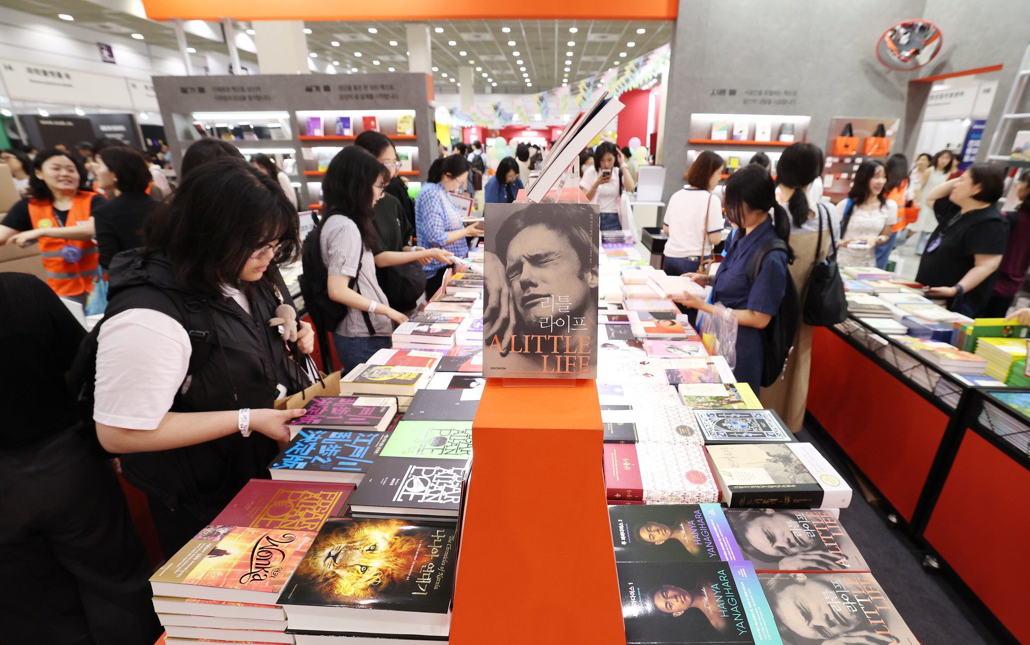 Un groupe de personnes feuillette des livres étalés sur un stand du salon international du livre de Séoul 2025, au centre des expositions Coex, le 18 juin 2025. © Lee Jeong Woo / Korea.net
