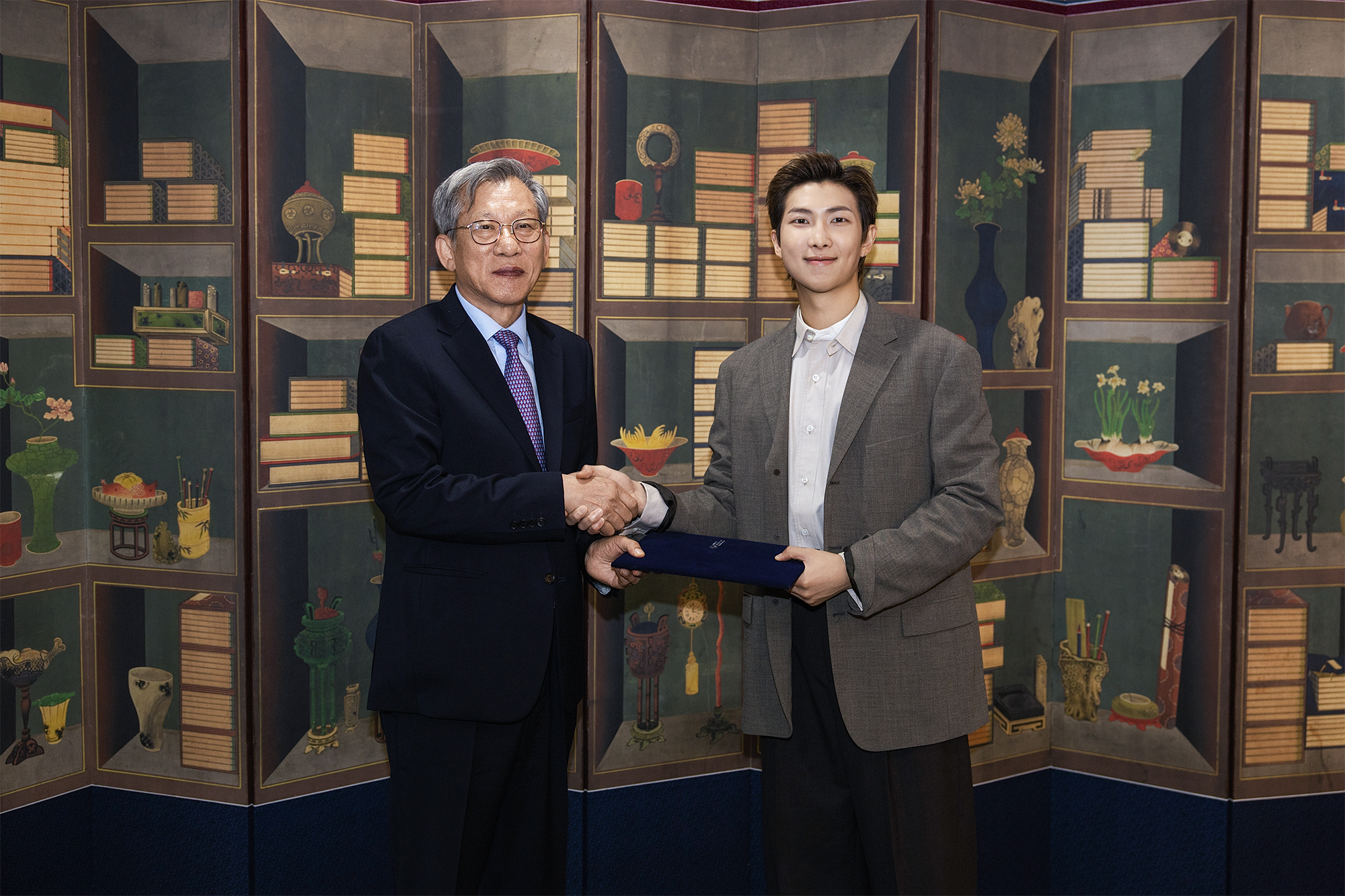 Le directeur du Musée national de Corée Yoo Hong-jun et le leader de BTS RM échangent une poignée de main, le 19 juin 2026. © Musée national de Corée