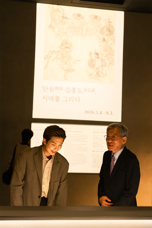 RM contemple des œuvres de l’exposition « Danwon Kim Hong-do, Painting His Era » en compagnie du directeur du Musée national de Corée Yoo Hong-jun, le 19 juin 2026. © Musée national de Corée