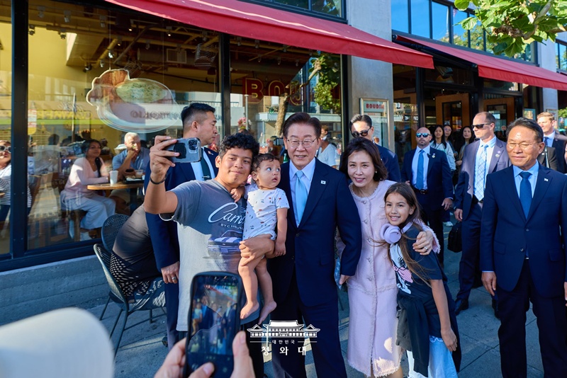 Le pr&eacute;sident Lee Jae Myung et son &eacute;pouse Kim Hea Kyung posent pour un selfie avec un habitant dans une rue de San Francisco, le 25 juillet 2026. &copy; Cheong Wa Dae