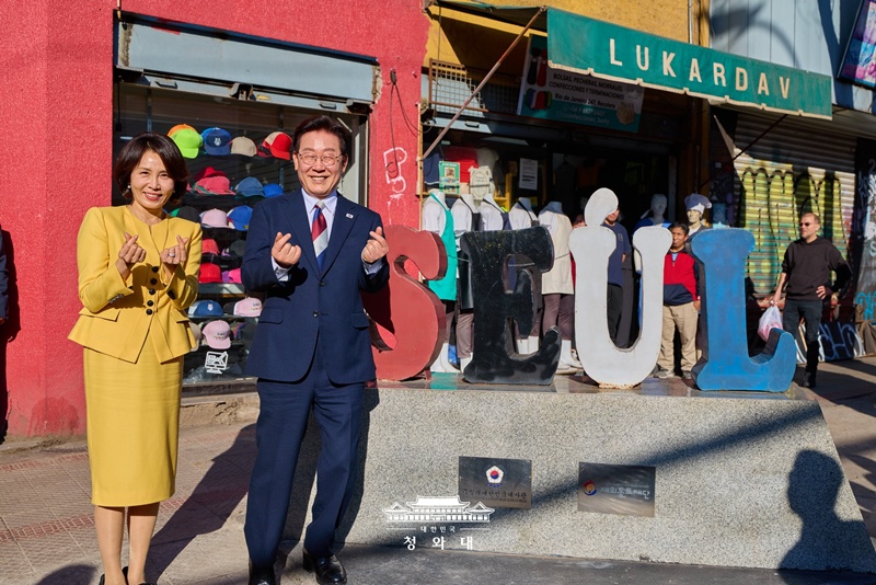 Le pr&eacute;sident Lee Jae Myung et son &eacute;pouse Kim Hea Kyung posent aux c&ocirc;t&eacute;s d&rsquo;une sculpture &agrave; l&rsquo;effigie de S&eacute;oul install&eacute;e dans le quartier multiculturel de Patrinato, o&ugrave; se trouvent de nombreux commerces cor&eacute;ens, &agrave; Santiago, le 30 juillet 2026. &copy; Cheong Wa Dae