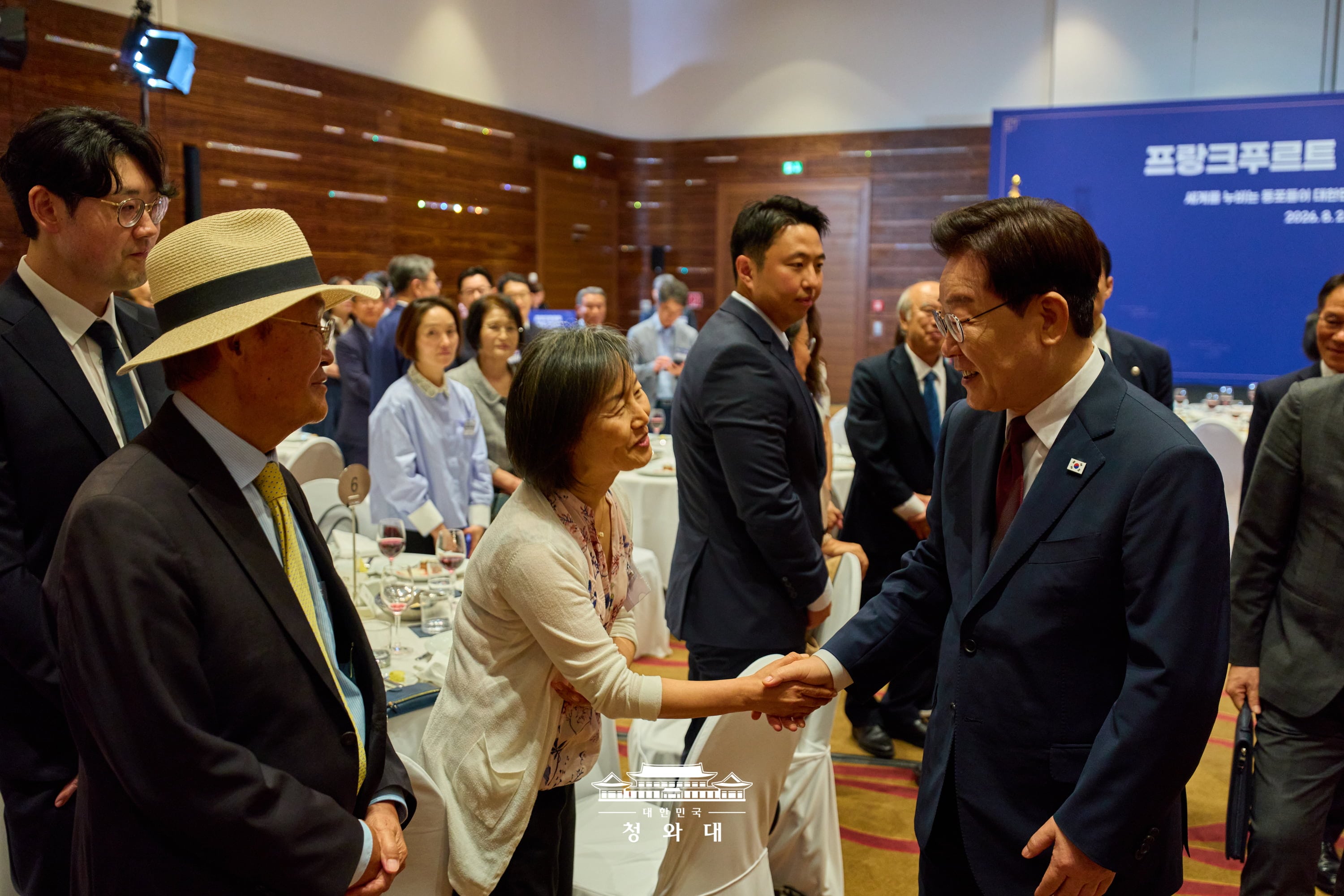 Le pr&eacute;sident Lee Jae Myung serre la main d&rsquo;une femme lors d&rsquo;une rencontre avec la communaut&eacute; cor&eacute;enne de Francfort, le 2 ao&ucirc;t 2026. &copy; Cheong Wa Dae