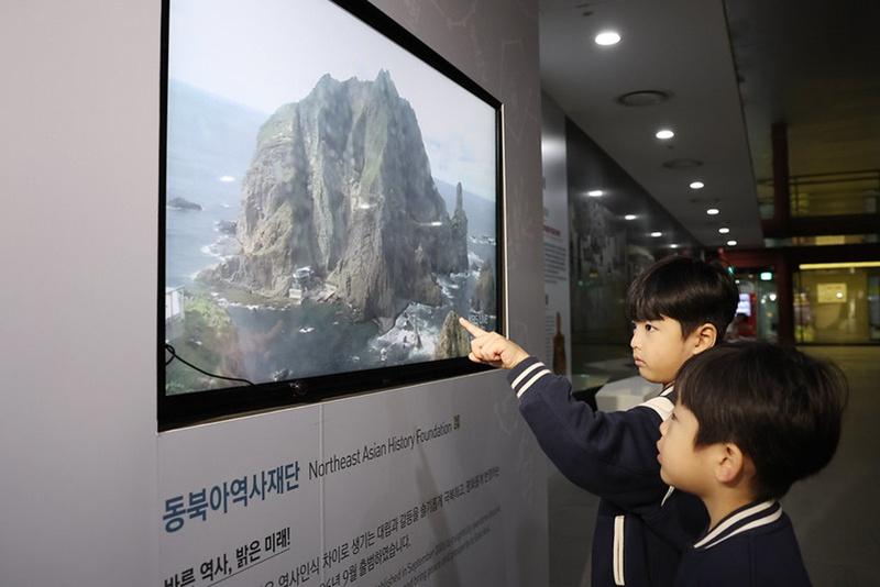 Des enfants regardent une vidéo dans une salle d’exposition consacrée aux îles Dokdo, sur la place de Gwanghwamun, à Séoul, le 24 octobre 2025. © Korea.net DB