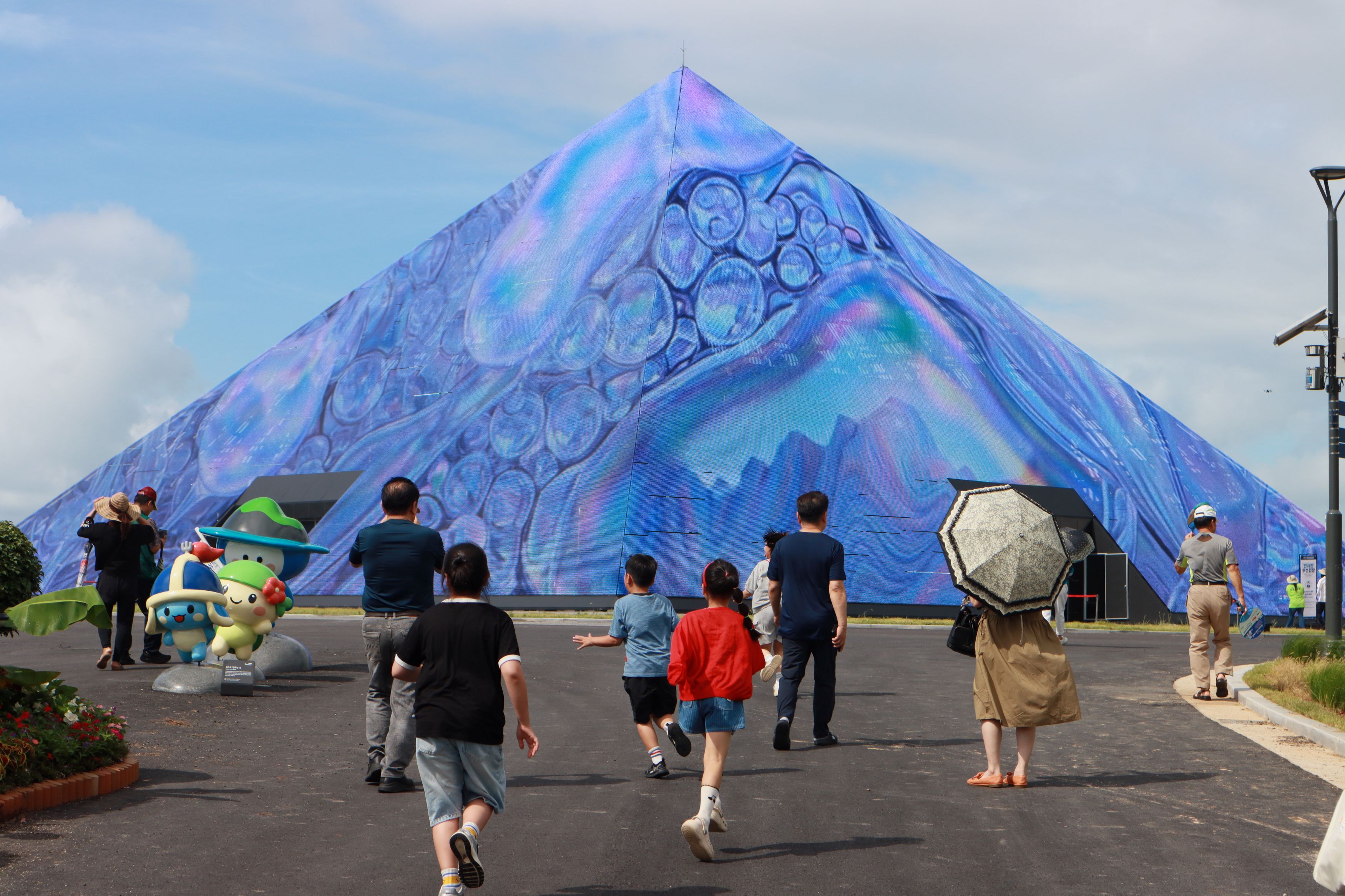 Un groupe de personnes se dirige vers le pavillon central de la 2026 World Island Fair Yeosu Korea, lors d&rsquo;une journ&eacute;e de pr&eacute;ouverture organis&eacute;e le 29 ao&ucirc;t 2026. &copy; Organizing Committee for the 2026 World Island Fair Yeosu Korea